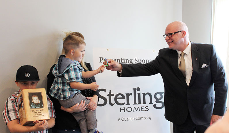 Sterling Homes presents house keys at a Habitat for Humanity key ceremony.